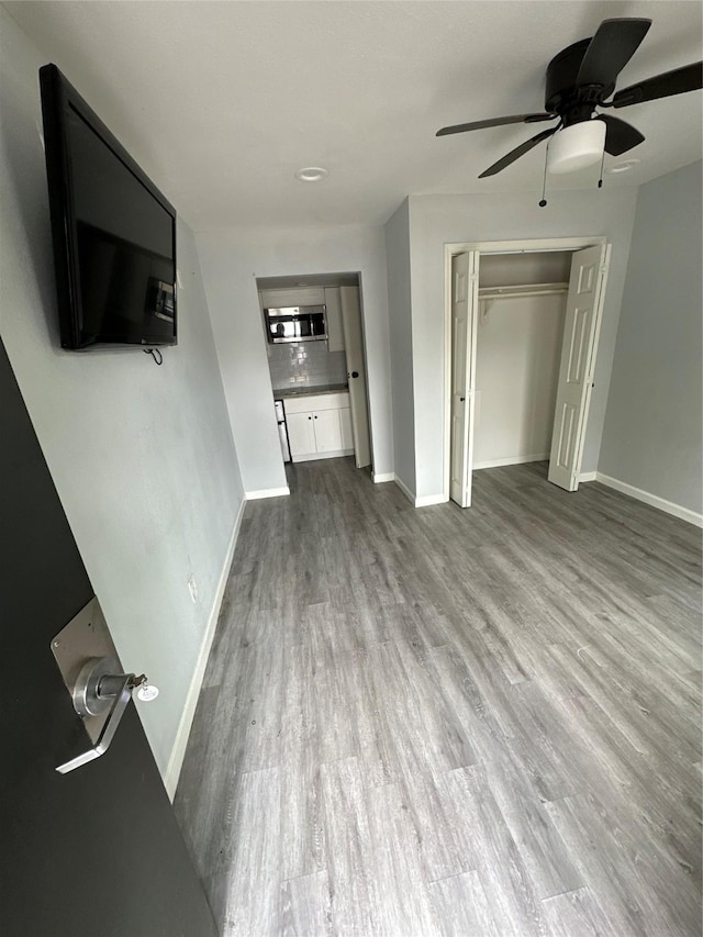 unfurnished living room with hardwood / wood-style flooring and ceiling fan