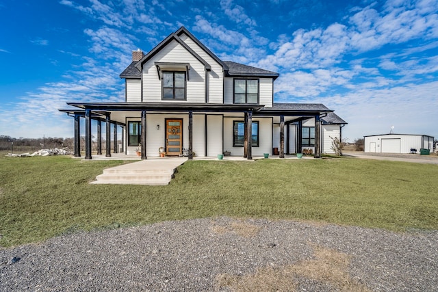 view of front of house with a garage, an outbuilding, and a front lawn