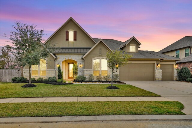 view of front of property featuring a garage and a lawn