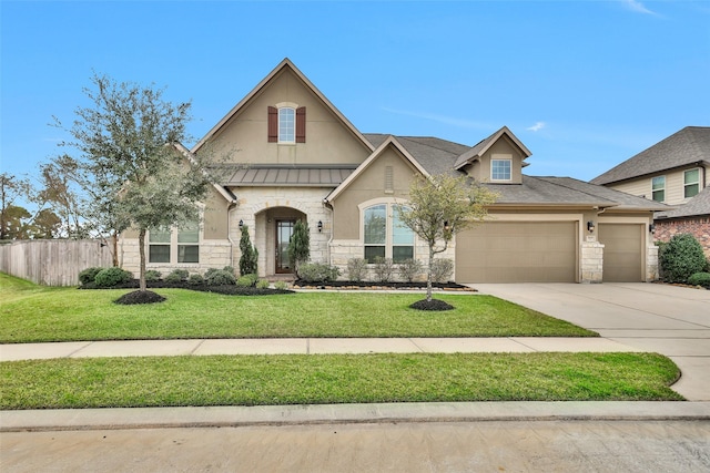 view of front of property with an attached garage, fence, stone siding, concrete driveway, and a front yard