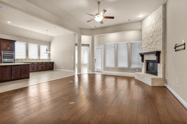 unfurnished living room featuring light wood-type flooring, ceiling fan, and a fireplace