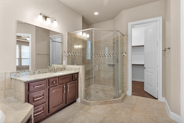 bathroom with ceiling fan, walk in shower, tile patterned floors, and vanity