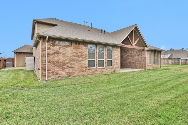 back of house featuring a lawn and a garage