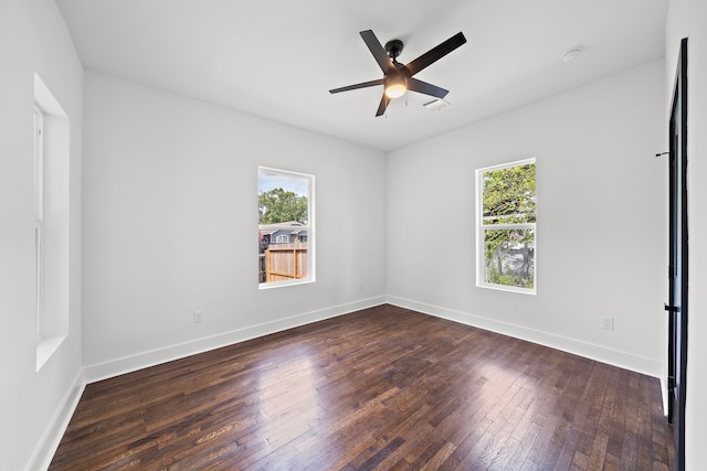 unfurnished room featuring ceiling fan, a wealth of natural light, and dark hardwood / wood-style flooring