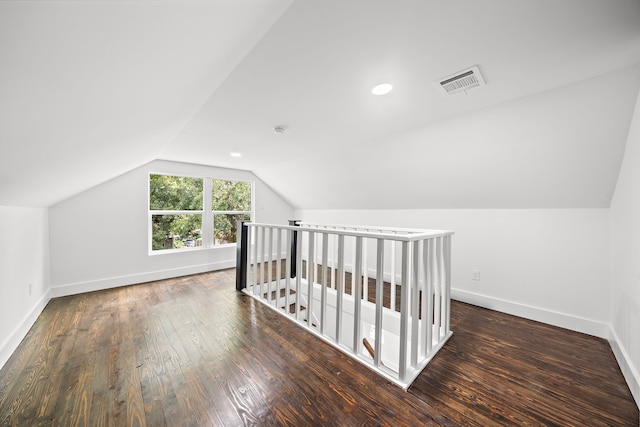 additional living space featuring dark hardwood / wood-style flooring and vaulted ceiling