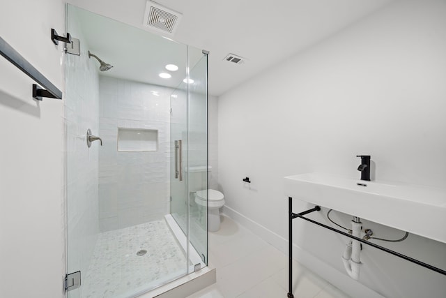 bathroom with toilet, walk in shower, and tile patterned flooring