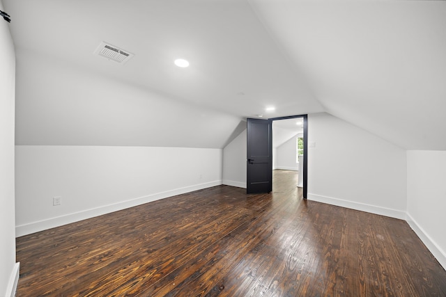 bonus room featuring vaulted ceiling and dark wood-type flooring