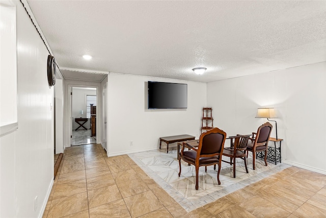 living area featuring baseboards and a textured ceiling