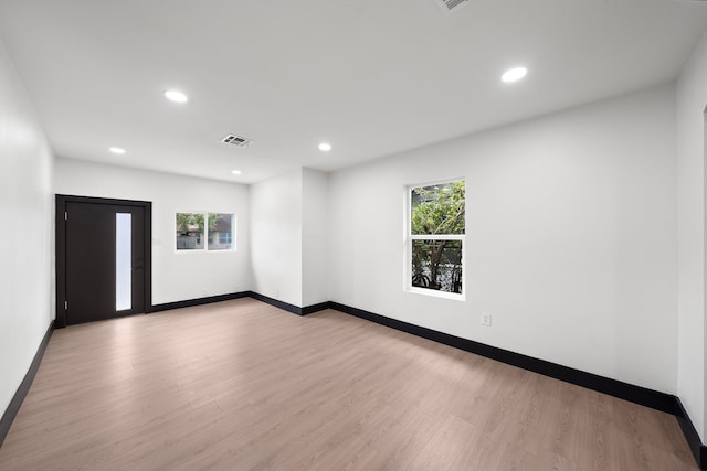 empty room with light hardwood / wood-style floors and a healthy amount of sunlight