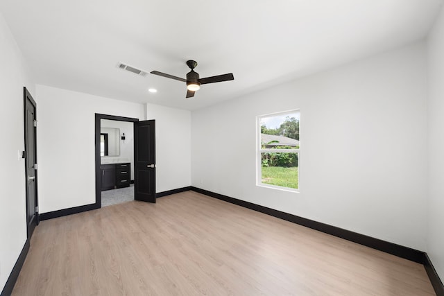 unfurnished bedroom with light wood-type flooring, ensuite bath, and ceiling fan