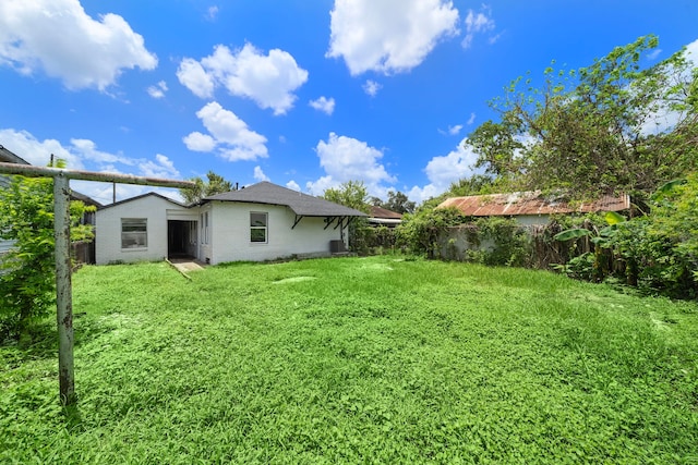 rear view of house featuring a yard