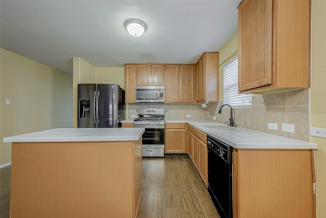 kitchen with appliances with stainless steel finishes, tasteful backsplash, sink, a center island, and light hardwood / wood-style flooring