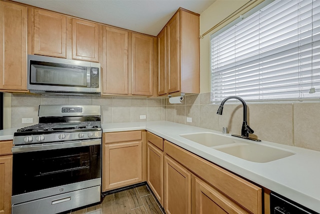 kitchen with sink, decorative backsplash, light hardwood / wood-style flooring, and stainless steel appliances