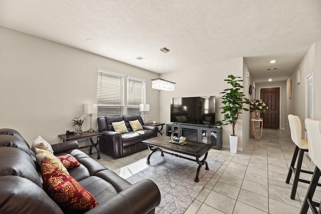 living room featuring a textured ceiling and light tile patterned floors