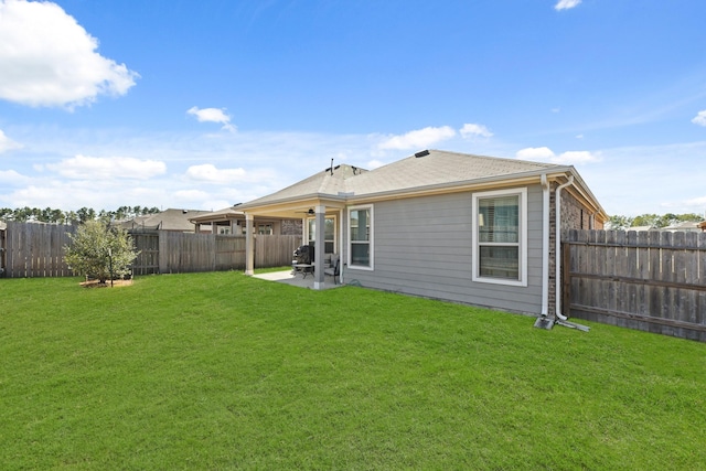 back of house featuring a lawn and a patio