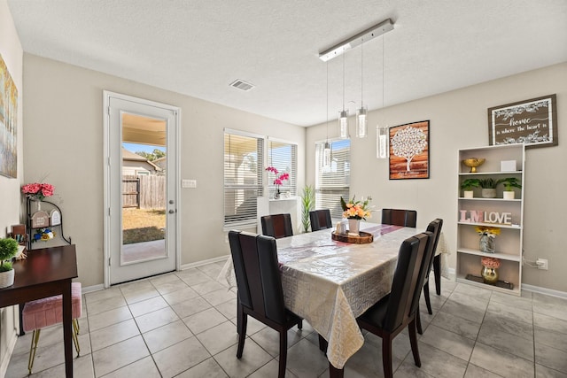 tiled dining area featuring a textured ceiling