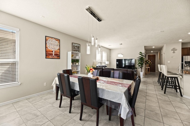 dining space featuring light tile patterned flooring and a textured ceiling