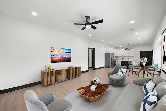 living room with ceiling fan and light hardwood / wood-style floors