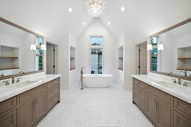 bathroom featuring vanity, built in shelves, tile walls, and a tub to relax in