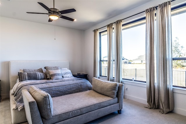 bedroom with multiple windows, light carpet, and ceiling fan