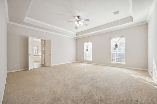 carpeted empty room with crown molding, ceiling fan, and a tray ceiling