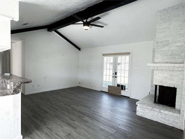 unfurnished living room with ceiling fan, french doors, lofted ceiling with beams, a fireplace, and a textured ceiling