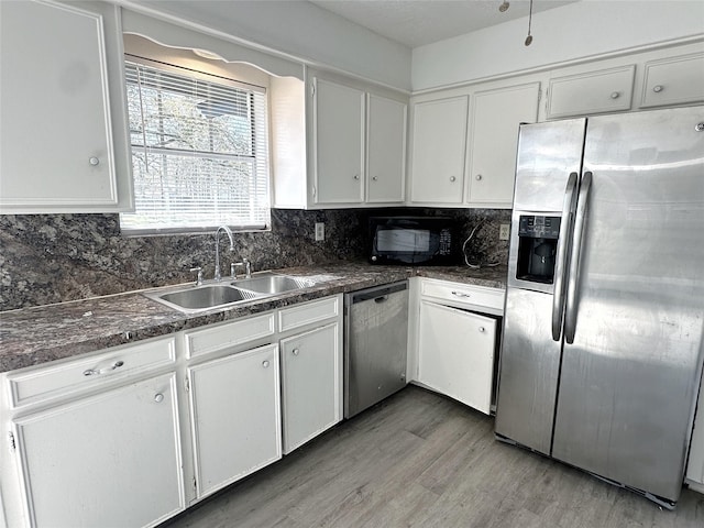 kitchen featuring sink, backsplash, white cabinetry, and stainless steel appliances