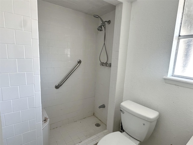 bathroom with toilet and tiled shower