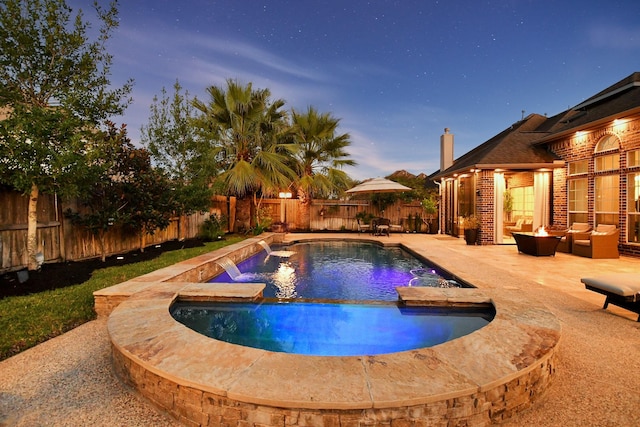 pool at dusk featuring an in ground hot tub, pool water feature, an outdoor living space with a fire pit, and a patio