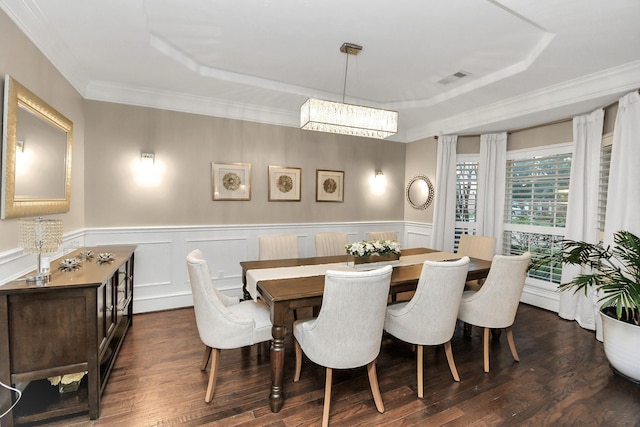 dining room featuring a raised ceiling, ornamental molding, and dark hardwood / wood-style floors