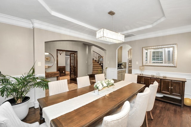 dining area featuring crown molding, a tray ceiling, and dark hardwood / wood-style floors