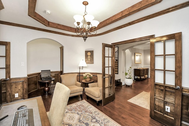 living room featuring a notable chandelier, ornamental molding, french doors, dark hardwood / wood-style flooring, and a raised ceiling