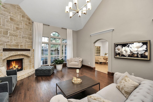 living room with high vaulted ceiling, dark hardwood / wood-style floors, a chandelier, and a fireplace