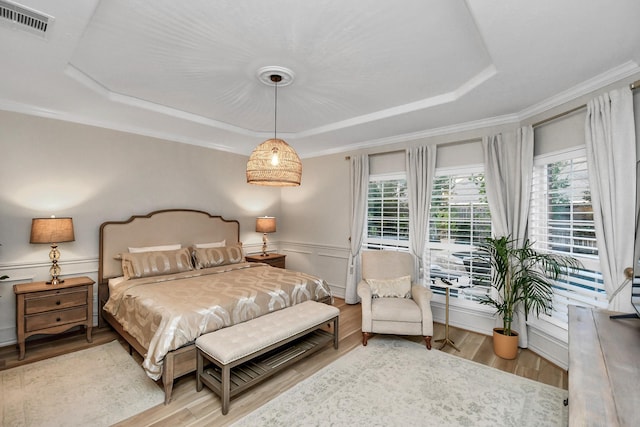 bedroom with hardwood / wood-style flooring and a raised ceiling