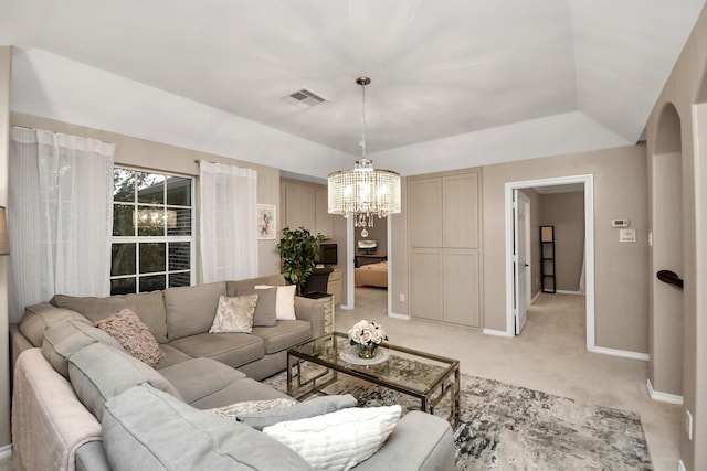 living room featuring light colored carpet, an inviting chandelier, and a tray ceiling