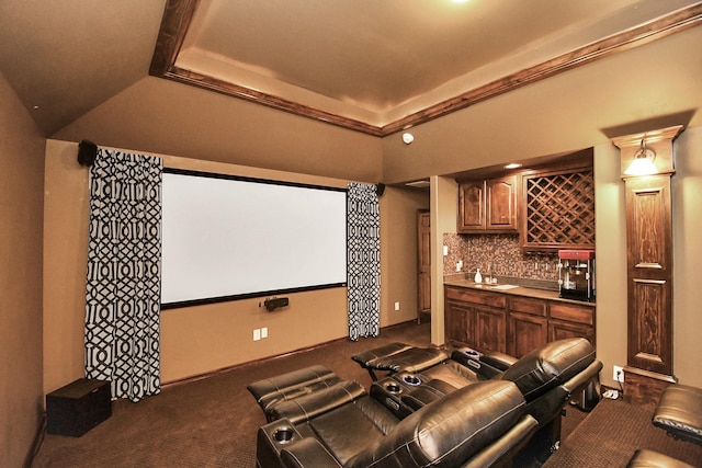 carpeted cinema with a raised ceiling and indoor wet bar