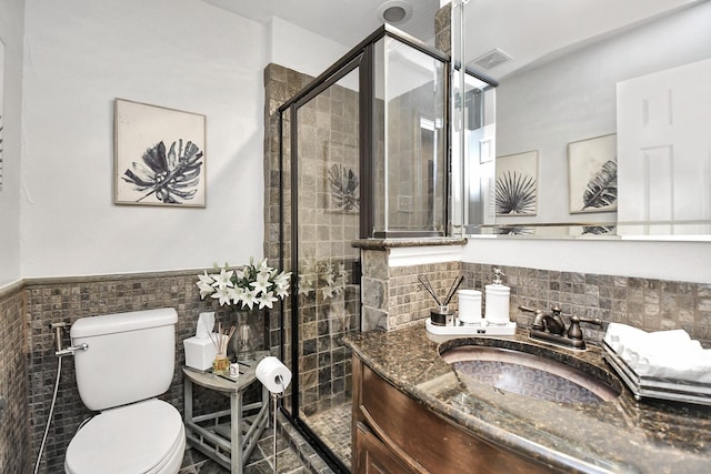 bathroom featuring tile walls, vanity, toilet, and walk in shower