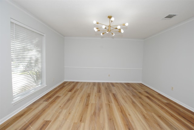 unfurnished room featuring hardwood / wood-style flooring, ornamental molding, and a chandelier