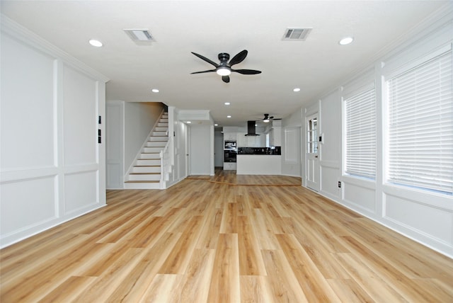 unfurnished living room with crown molding, light hardwood / wood-style flooring, and ceiling fan