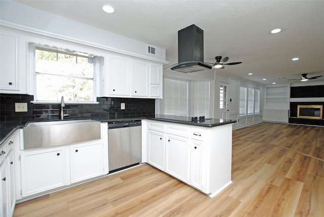 kitchen with dishwasher, white cabinetry, island range hood, sink, and kitchen peninsula