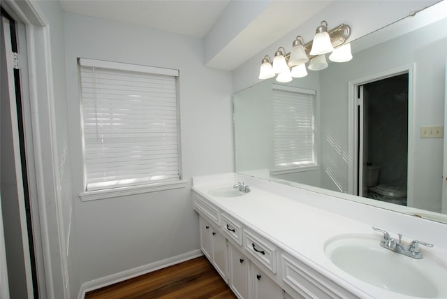 bathroom with hardwood / wood-style flooring, toilet, and vanity