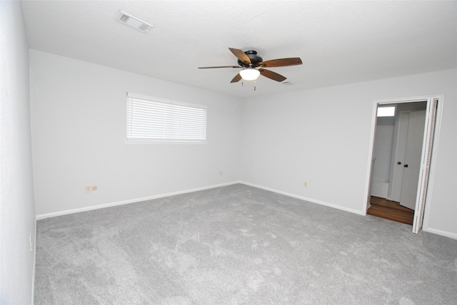 unfurnished room featuring ceiling fan and carpet