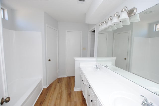 bathroom featuring a tub, hardwood / wood-style floors, and vanity