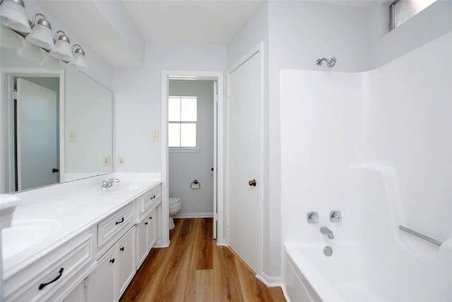 full bathroom with vanity, toilet, hardwood / wood-style floors, and shower / bathing tub combination