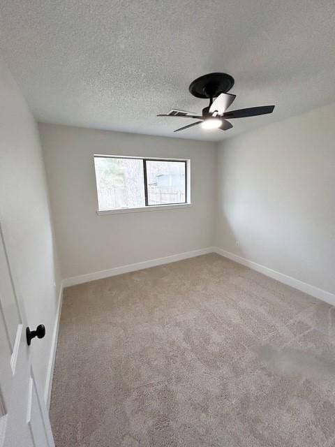 unfurnished room featuring ceiling fan, carpet, and a textured ceiling