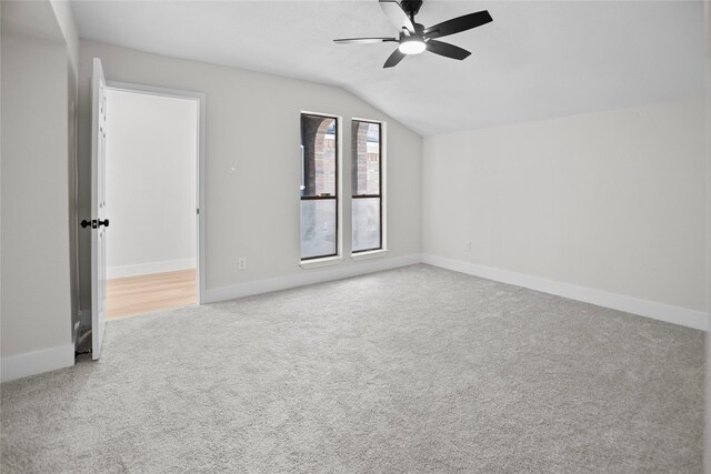 carpeted empty room with baseboards, ceiling fan, and vaulted ceiling