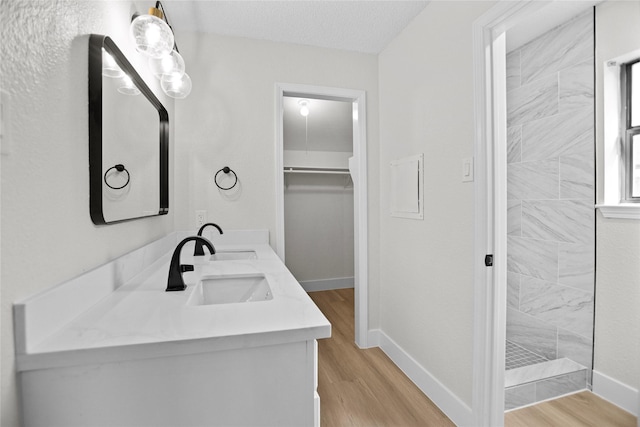 full bath featuring a sink, baseboards, and wood finished floors