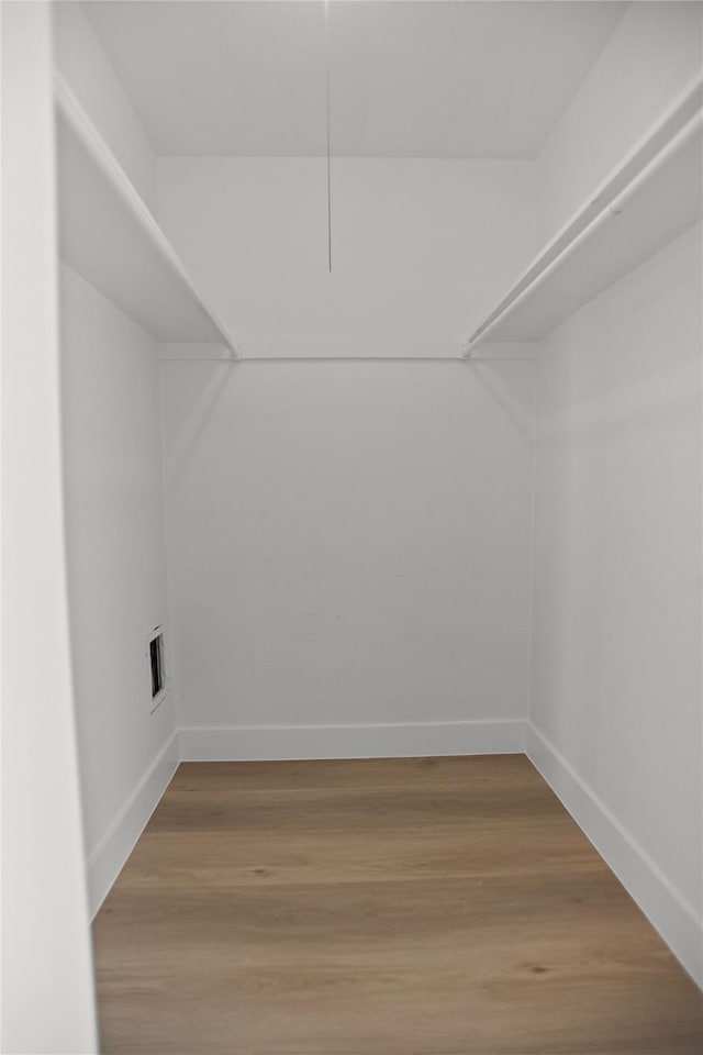 spacious closet featuring visible vents and wood finished floors