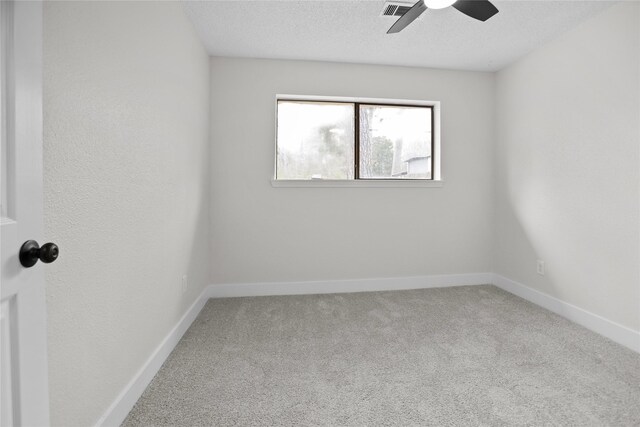 carpeted empty room featuring visible vents, a textured ceiling, baseboards, and a ceiling fan