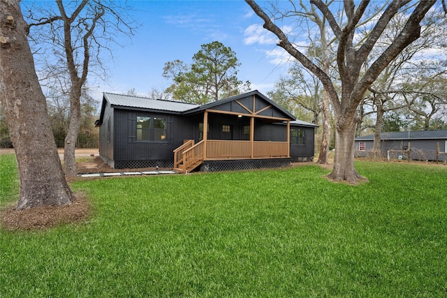 rear view of property with a lawn and a sunroom